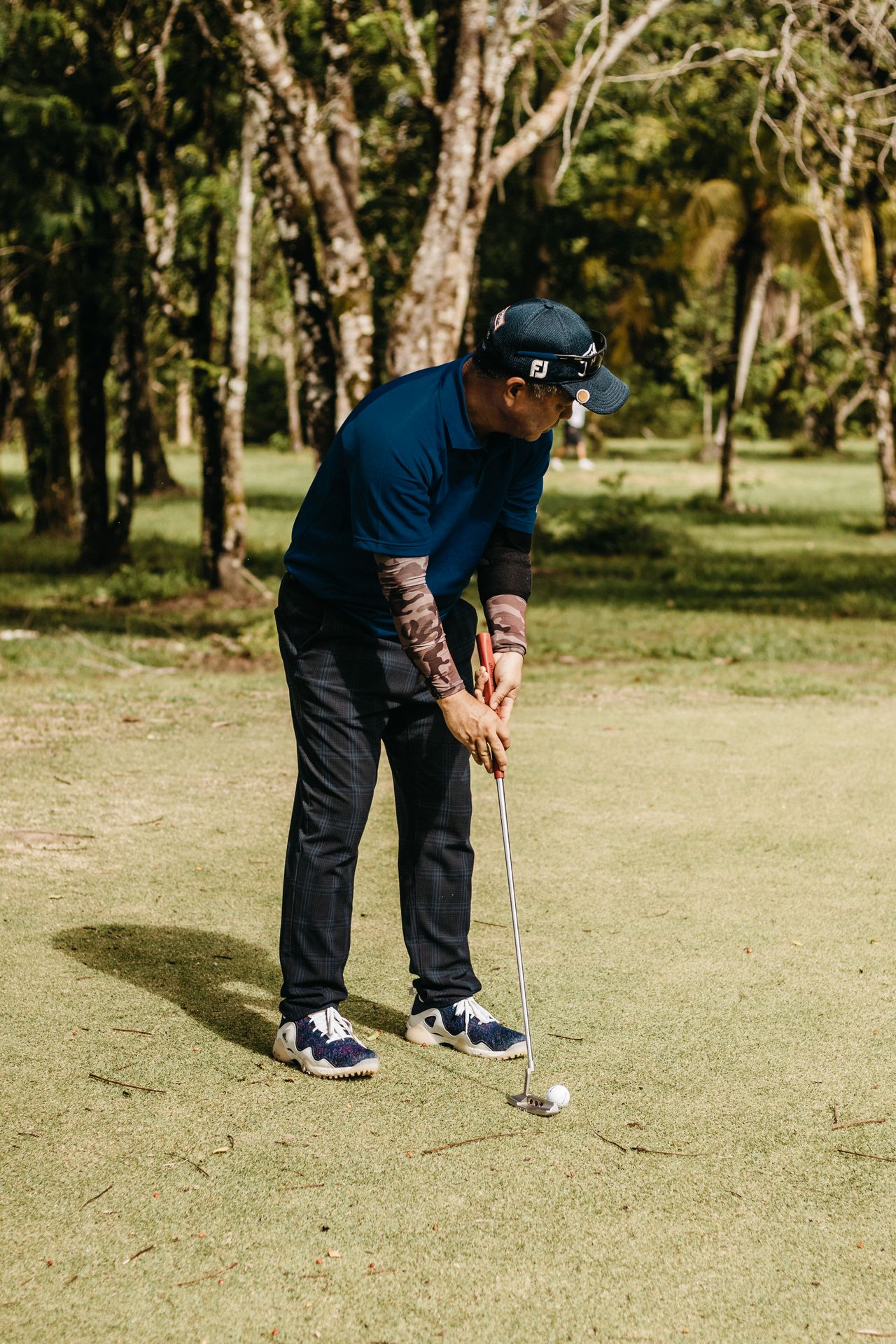 A golfer putting on a sunny green